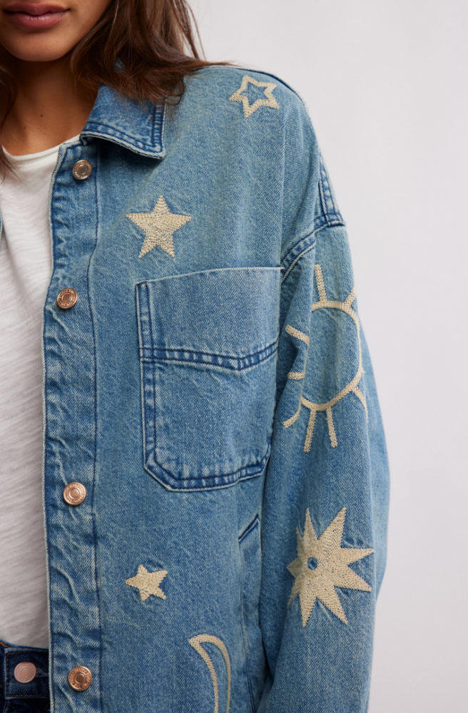 Women's denim jacket with celestial embroidery, front button closure and chest patch pocket.