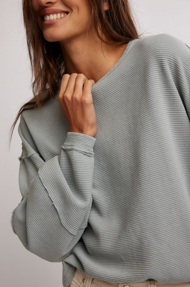 Women's grey-blue long sleeve top with exposed seams