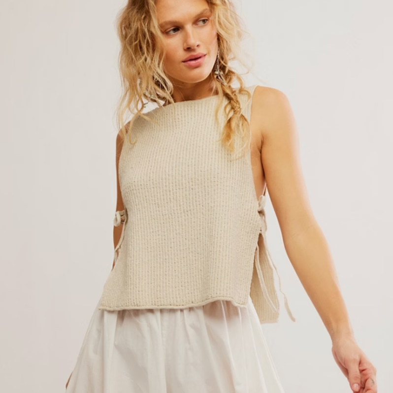 Woman wearing a light-colored sleeveless top and a  flowing skirt 