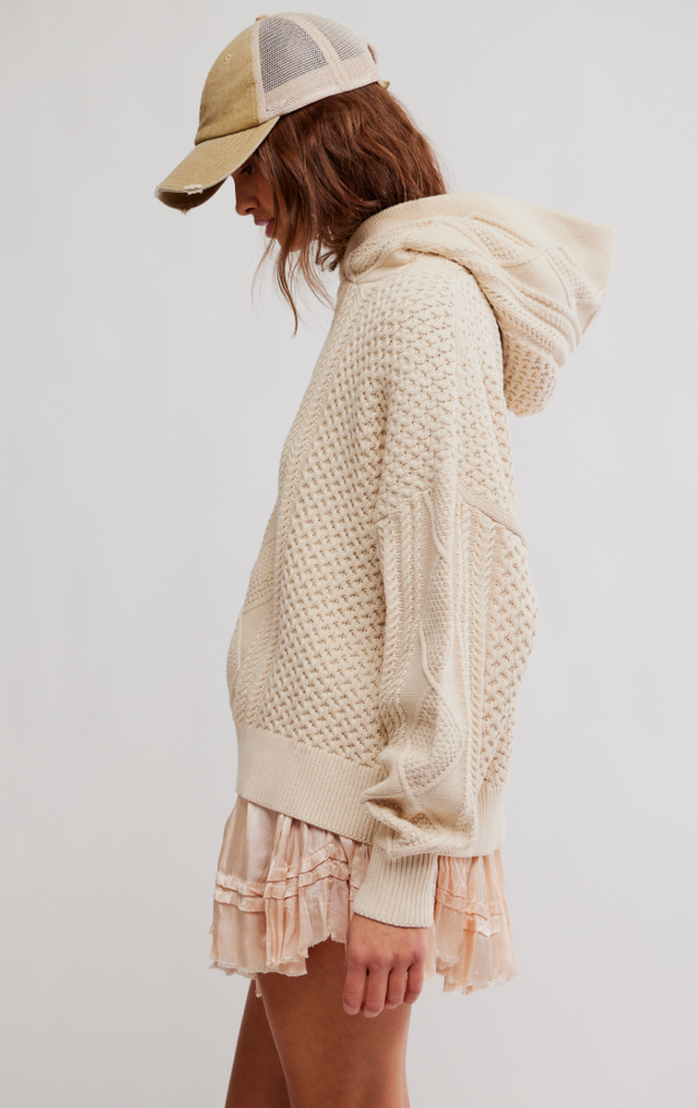 
                      
                        Woman wearing a beige knit sweater and cap 
                      
                    