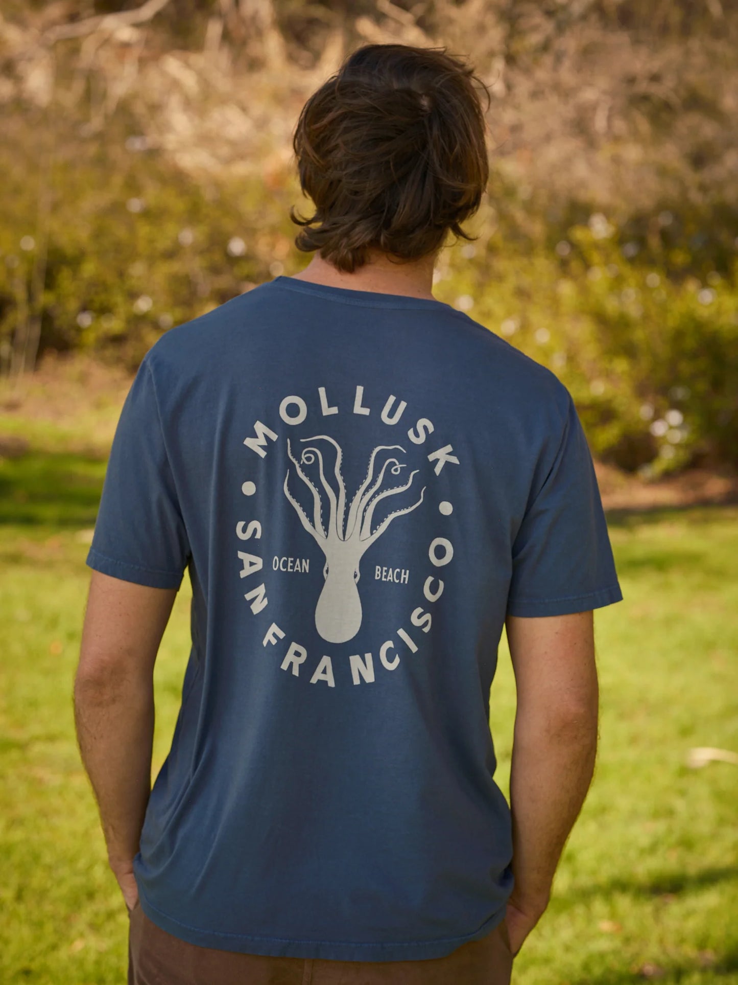 Load image into Gallery viewer, Back view of men&amp;#39;s navy color short sleeve t-shirt with an upside down octopus graphic on the back and the words Mollusk, San Francisco and Ocean Beach
