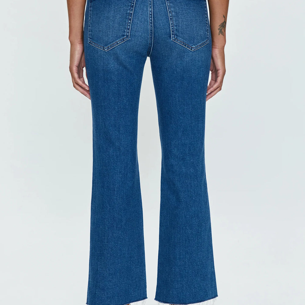 Back view of woman wearing medium wash high rise cropped bootcut jeans by Pistola