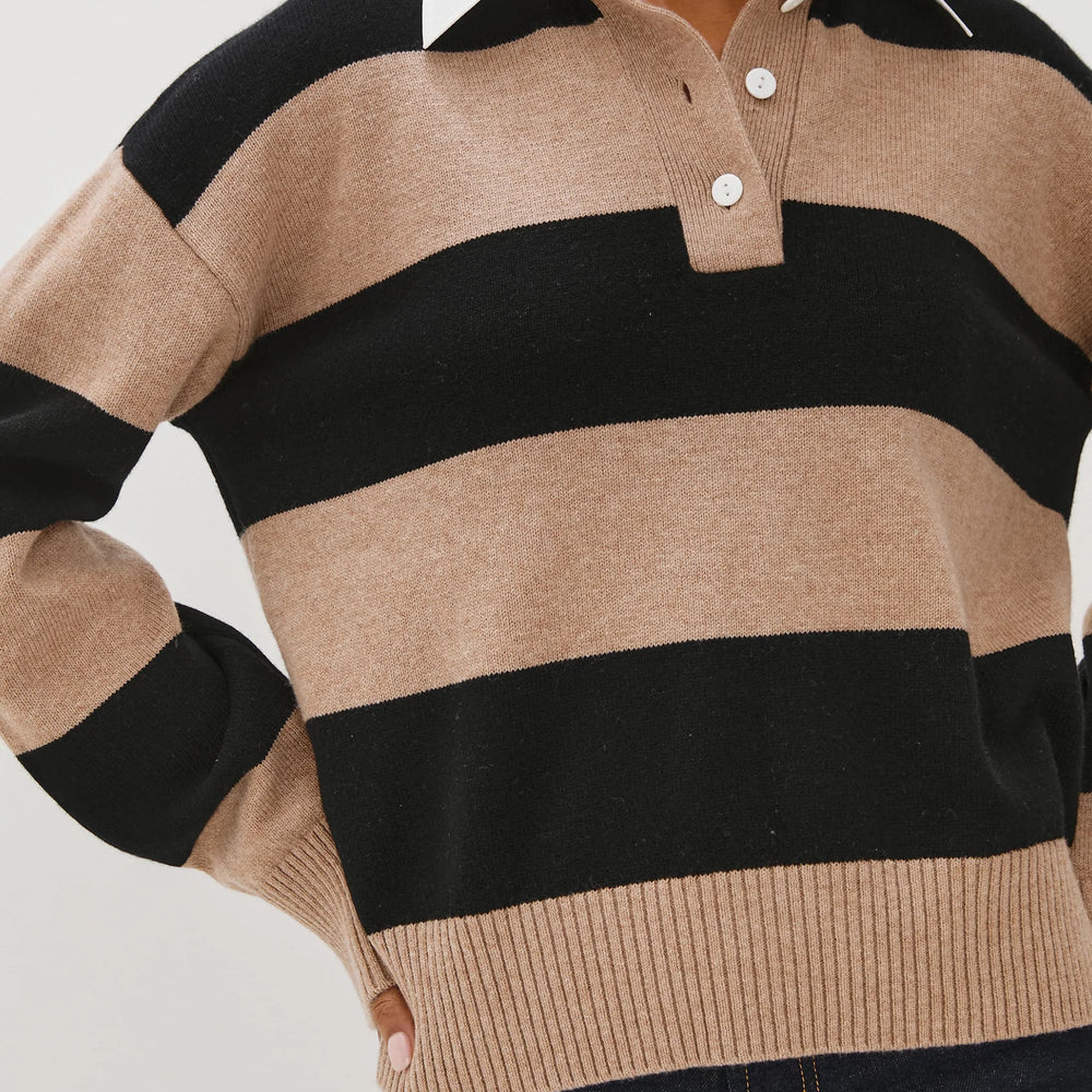 Person wearing a beige and black striped sweater with a white collar.