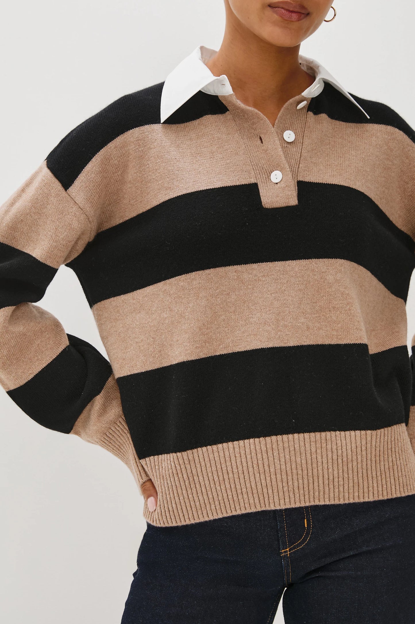 Person wearing a beige and black striped sweater with a white collar.