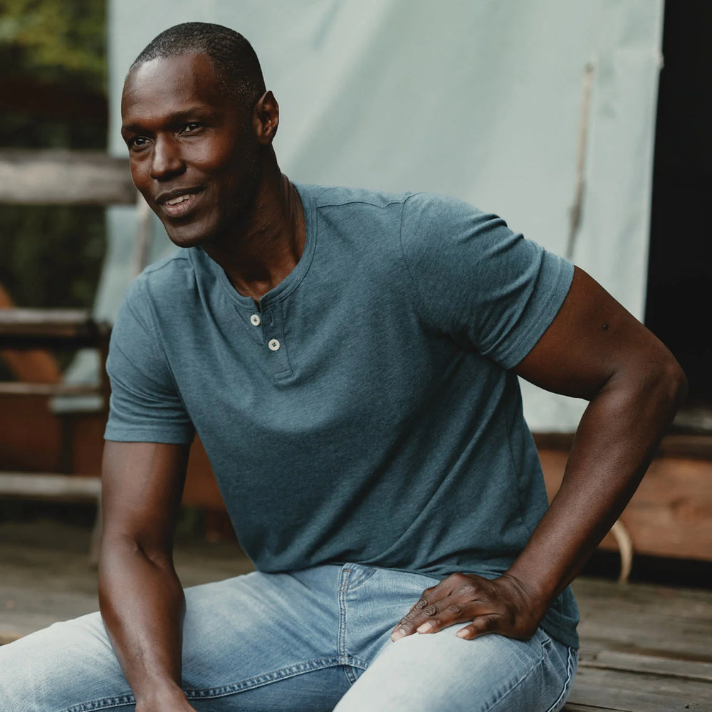 Man wearing The Normal Brand's Active Puremeso Weekend Henley in the color Pine