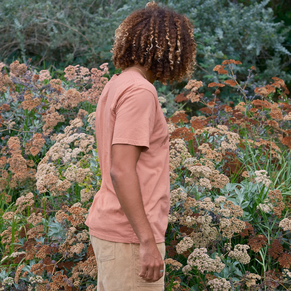 
                      
                        side view of man looking at flowers while wearing the short sleeve Pelican Tee
                      
                    