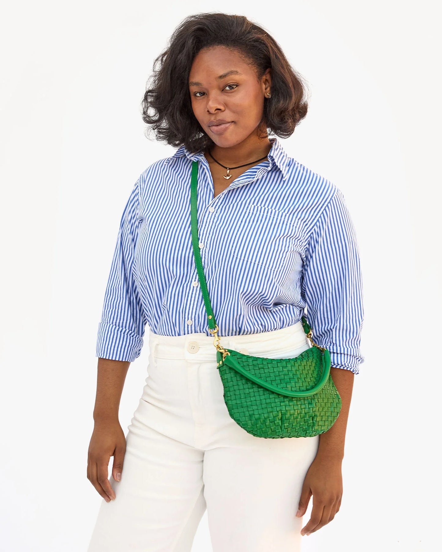 Woman wearing the Grass Woven Checker Petit Moyen Messenger Bag by Clare V. as a crossbody