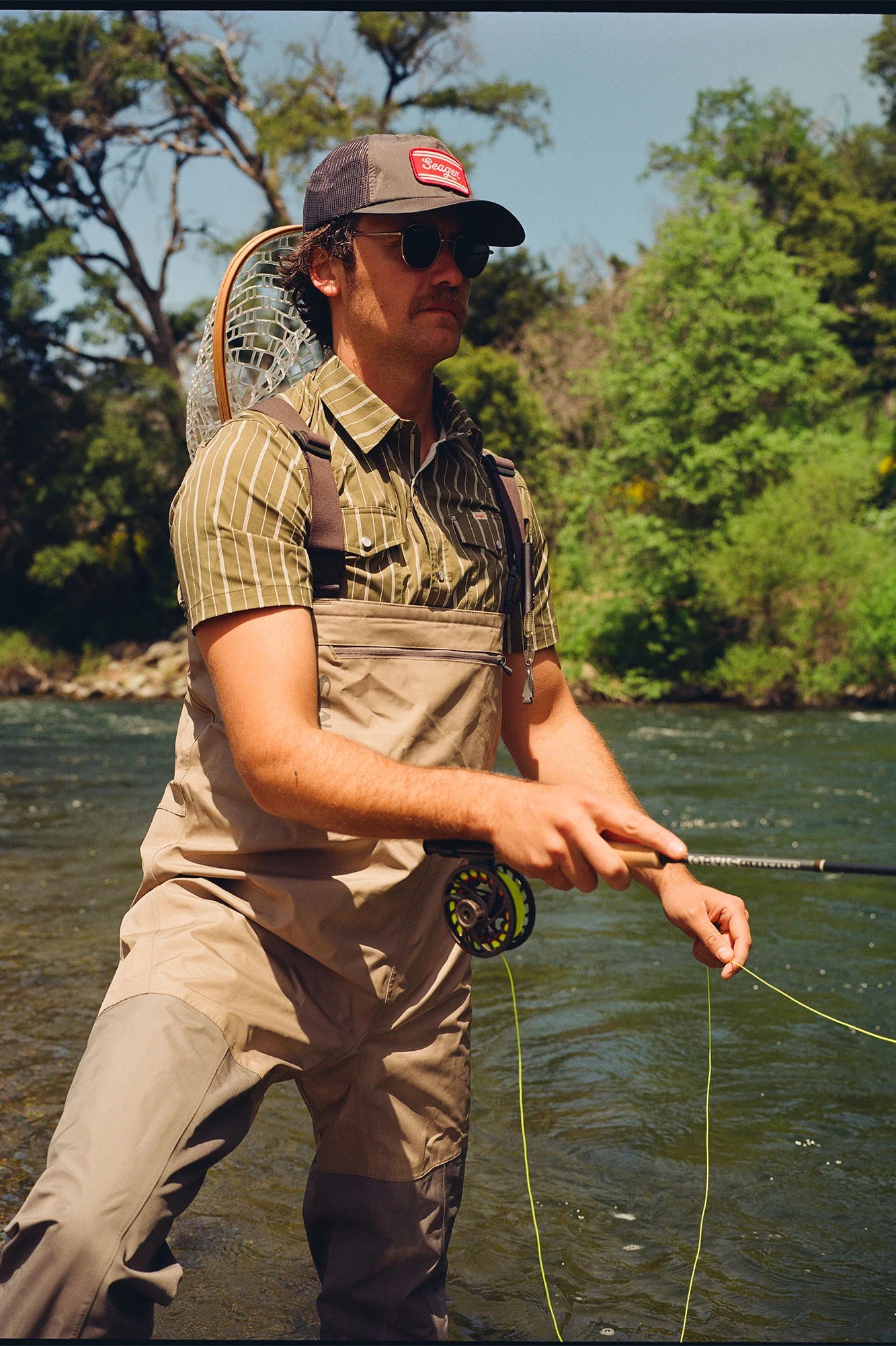 Man fly fishing while wearing the El Ranchero Short Sleeve Shirt by the brand Seager