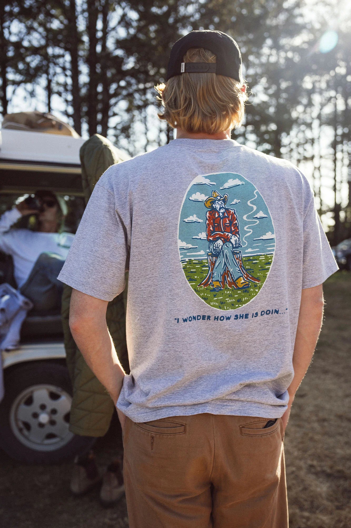 A man out with friends in the woods while wearing the Ponder Tee in Heather Grey by Seager