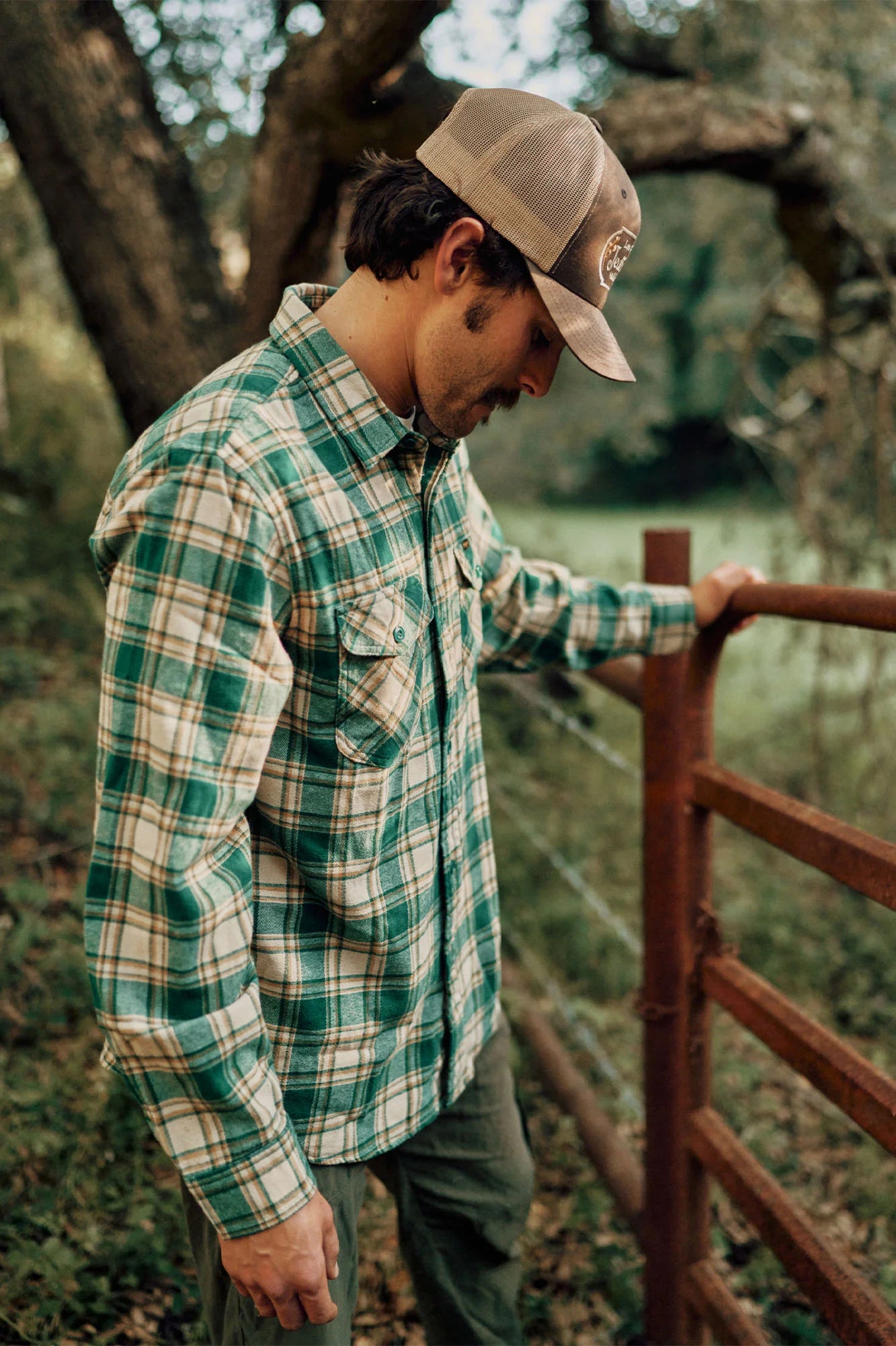 A man standing next to a fence while wearing the Calico Flannel Shirt by Seager