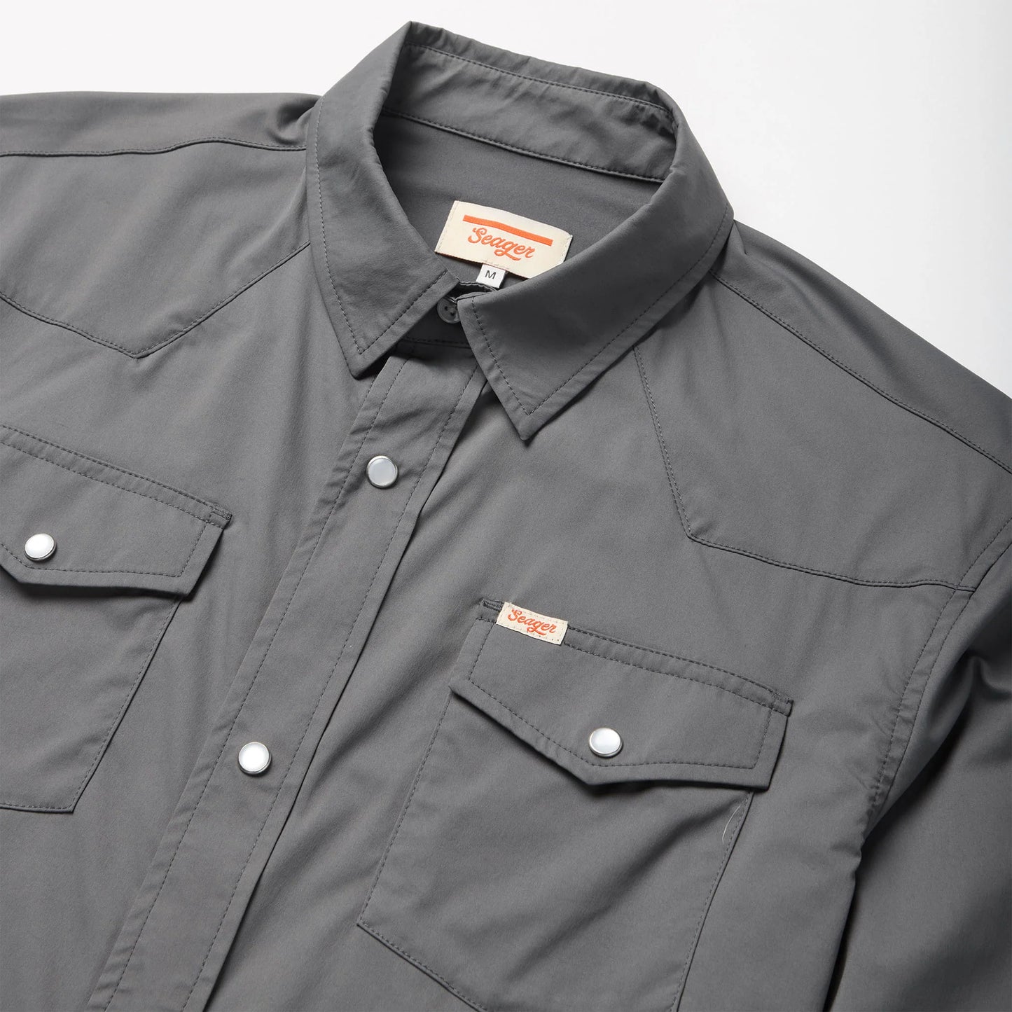 This pearl snap shirt features Western yoke over shoulders