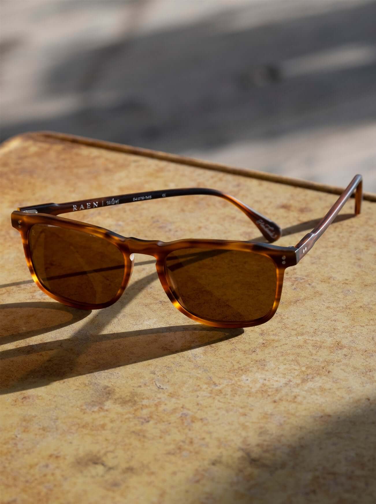 A pair of RAEN's Wiley Men's Square Sunglasses with Matte Rootbeer frames and Brown lenses