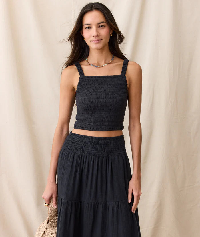 Woman wearing a black maxi skirt and cropped tank from Marine Layer
