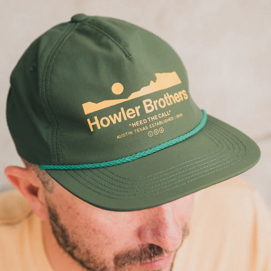 Man wearing the Howler Bros Howler Arroyo Unstructured Strapback Hat in the color Astroturf