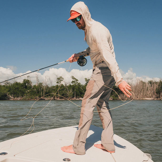 Man fishing on a boat wearing the Watermans Work Pant by Howler Bros