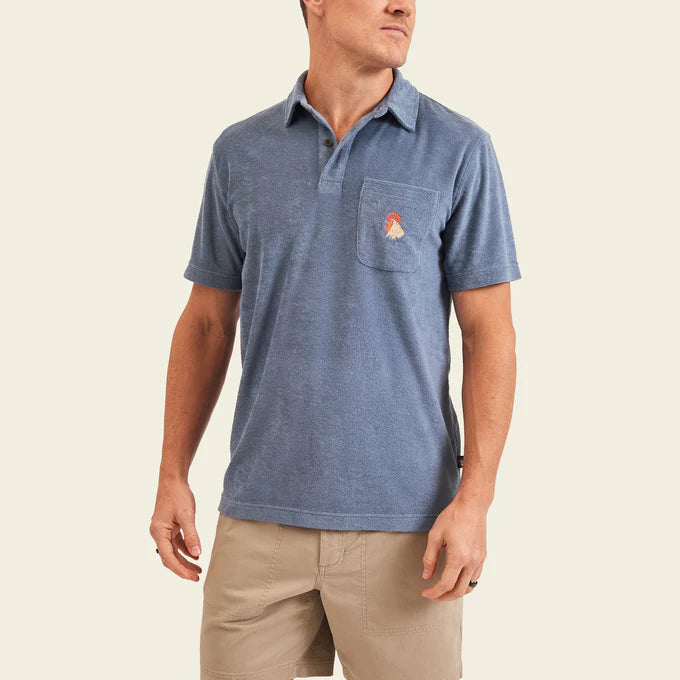 Front view of man wearing a plush blue short sleeve polo shirt with 2 button placket and single chest pocket with a rooster head design