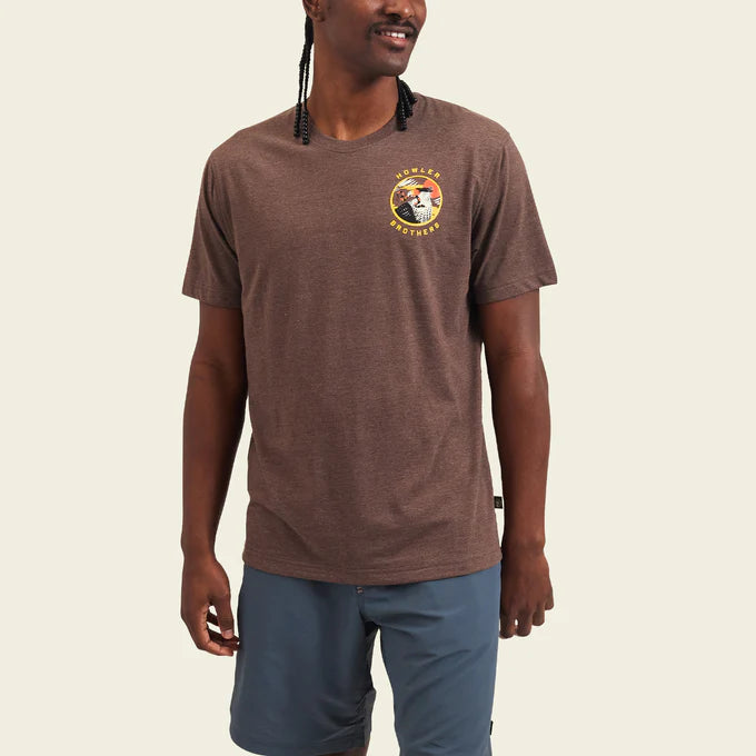 Front view of man wearing the brown short sleeve Caracara men's t-shirt by Howler Bros