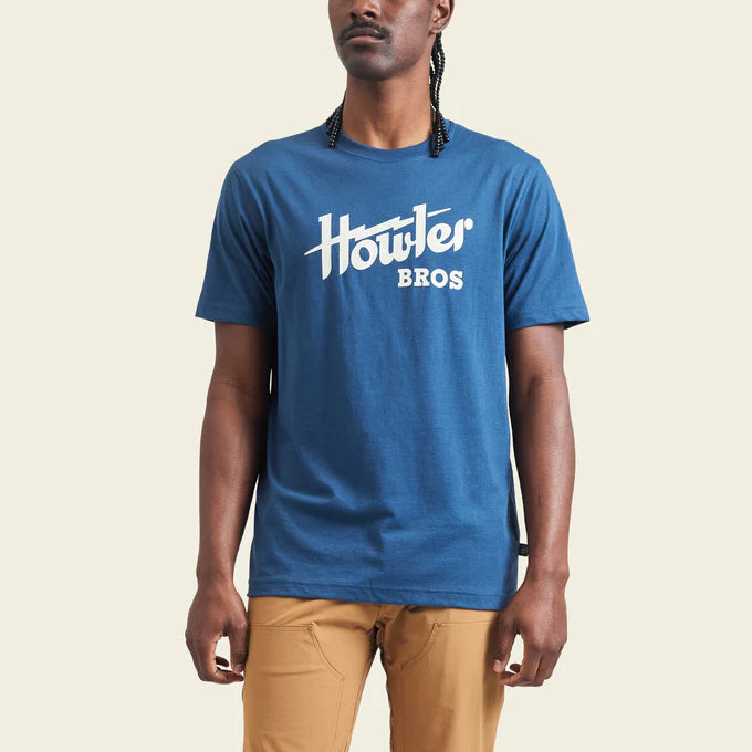 Front view of man wearing a blue Howler Bros short sleeve men's t-shirt