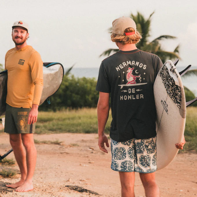 Outdoor lifestyle back view of man wearing the antique black color Ocean Offerings men's t-shirt by Howler Bros