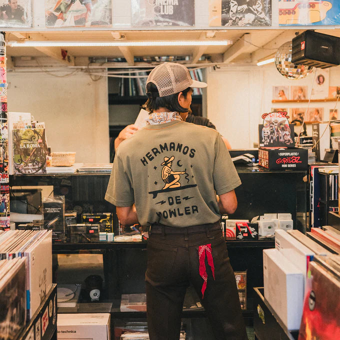 Lifestyle photo back view of man wearing the green Ocean Offerings Men's T-shirt by Howler Bros