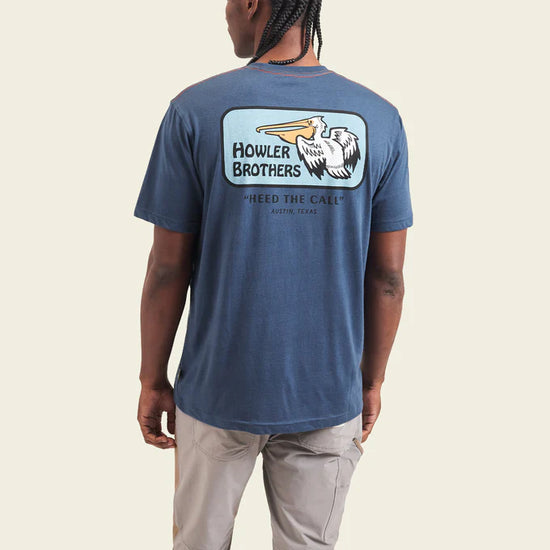 Back view of man wearing the blue Pelican Badge short sleeve t-shirt by Howler Bros