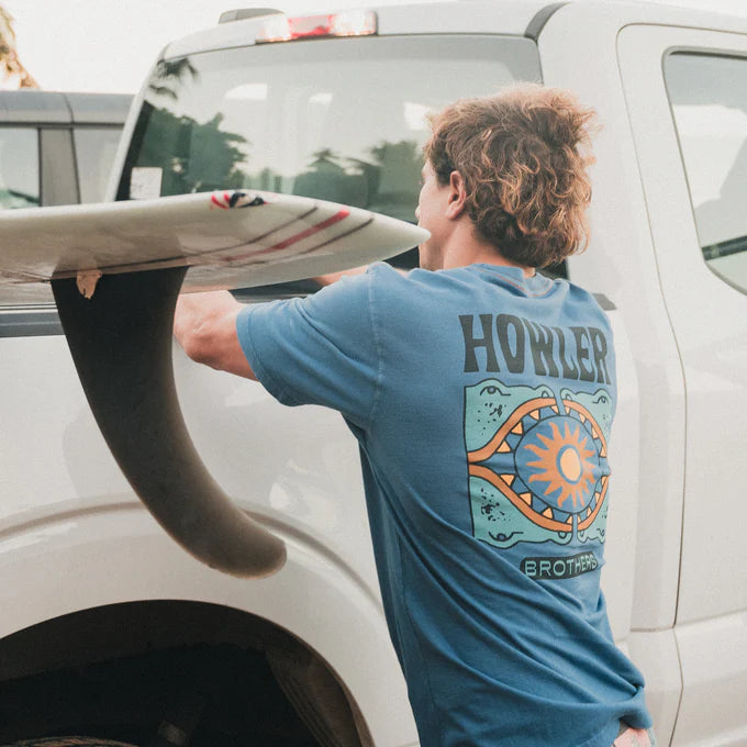 Man outside wearing the Howler Bros Sun Drinker Cotton T-Shirt in the color Blue