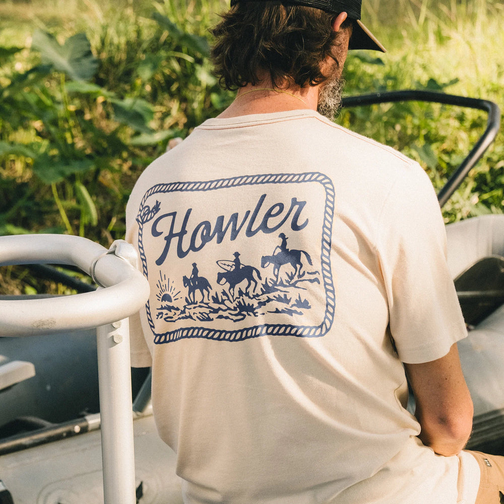 Person wearing a 'Howler' branded t-shirt with a n western style graphic design 