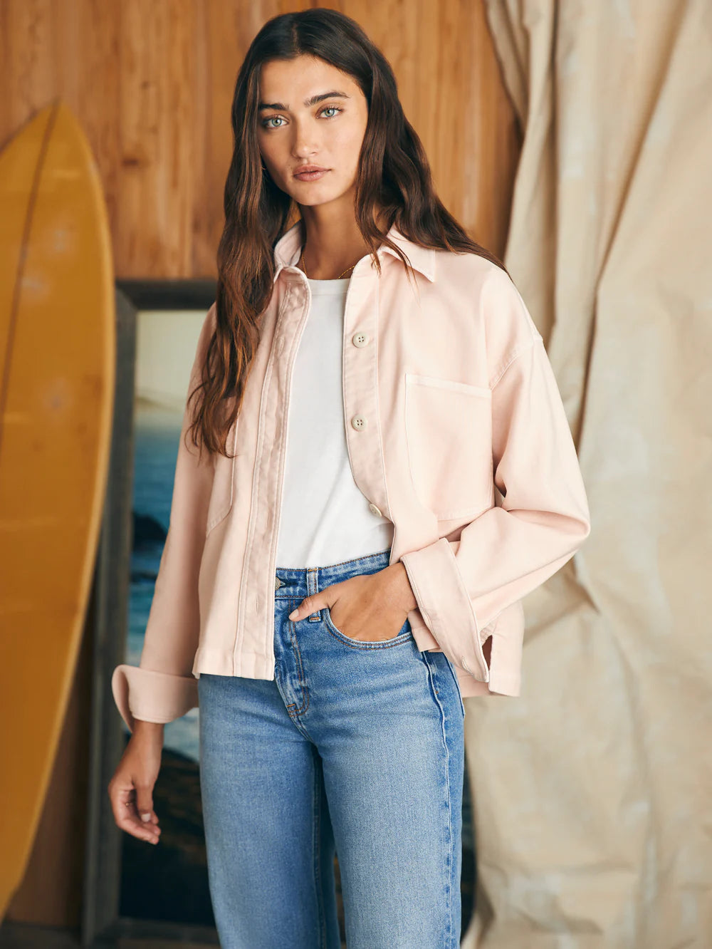 Front iew of woman wearing an unbuttoned peach color long sleeve overshirt
