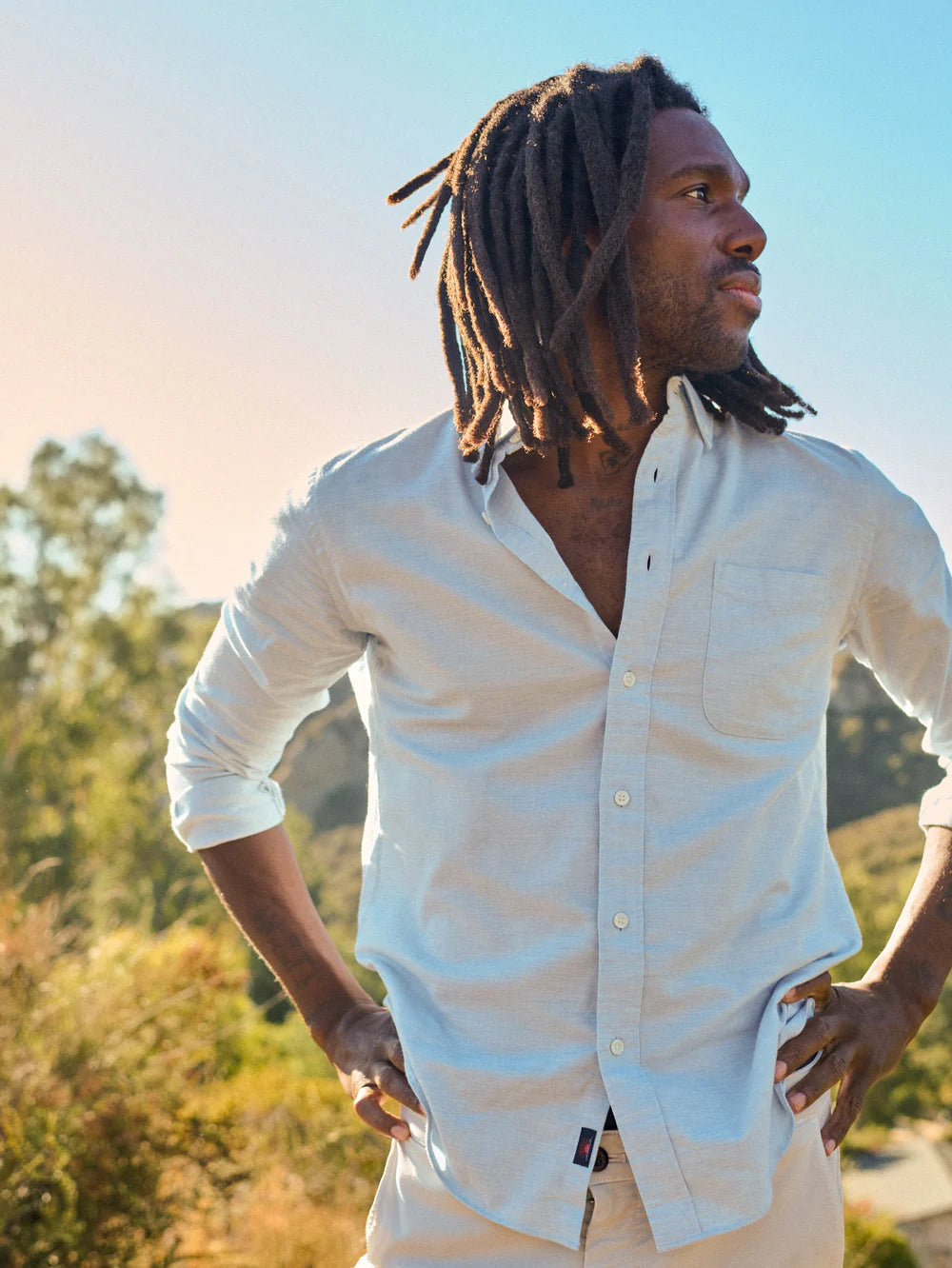 Man outside wearing Faherty's Supima Oxford Shirt in the color Blue Heather