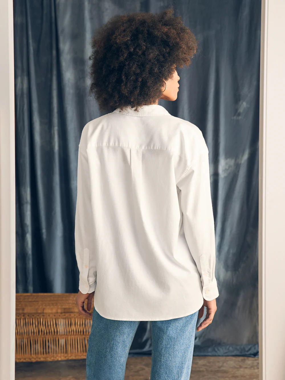 Back view of a woman wearing Faherty's Stretch Oxford Relaxed Shirt in the color White