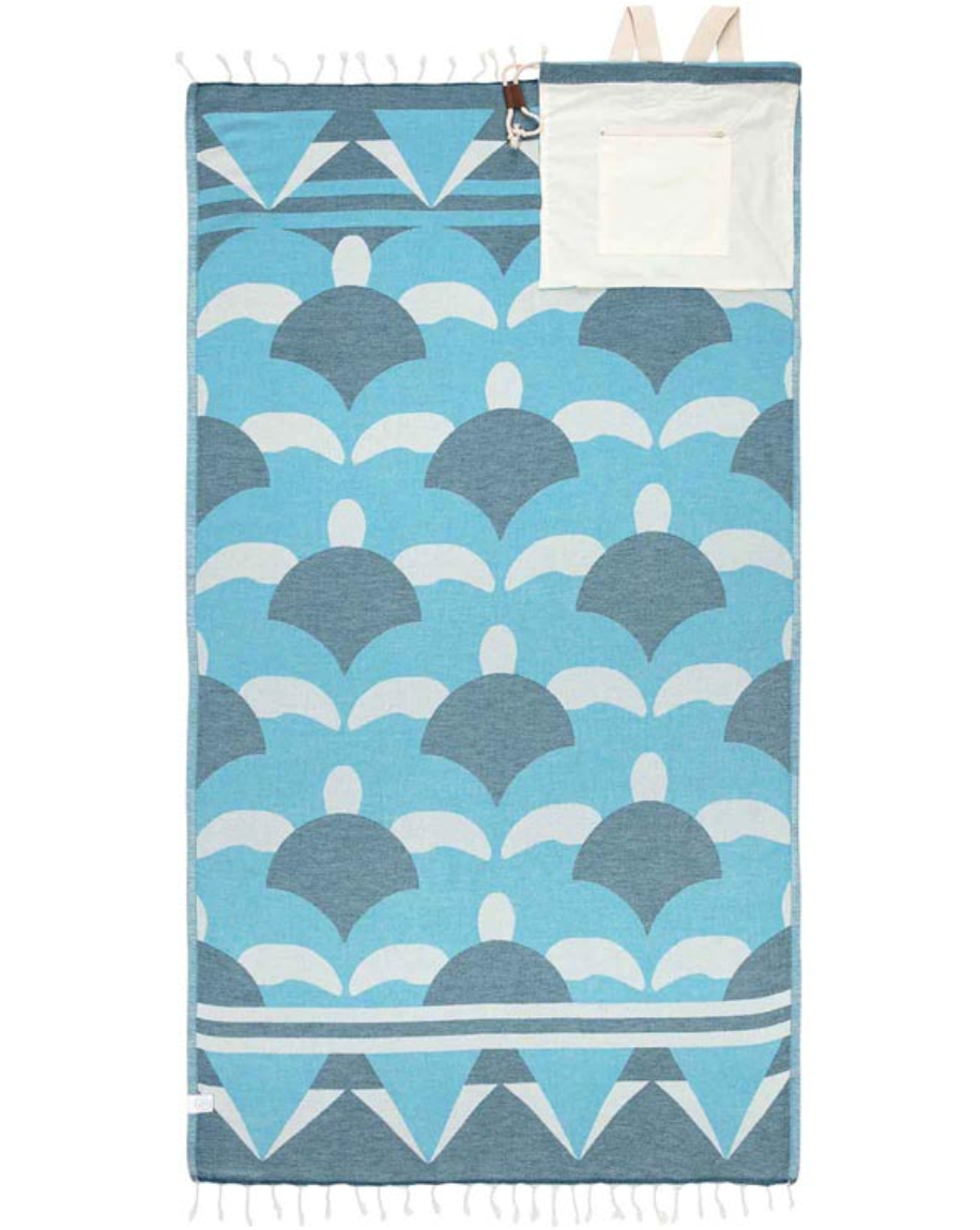Blue towel with tassels and hatchling turtles inspired design showing how it has the ability to fold into a bag