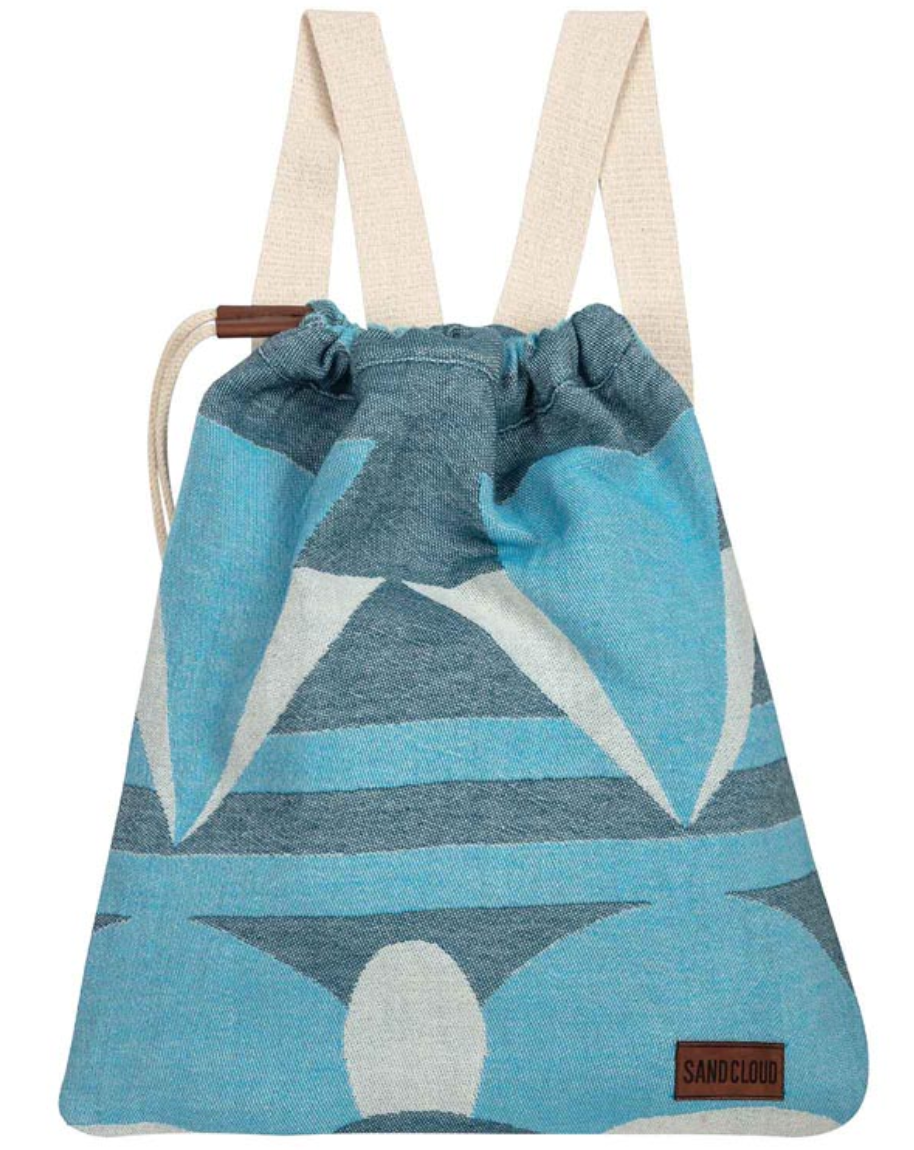Blue towel with tassels and hatchling turtles inspired design folded into it's self-packing bag shape with straps to carry like a backpack