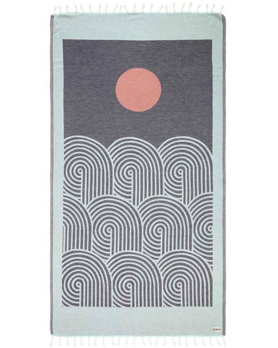 unfolded view of a sand cloud beach towel with an artful sun and sea inspired design and tassels at the ends