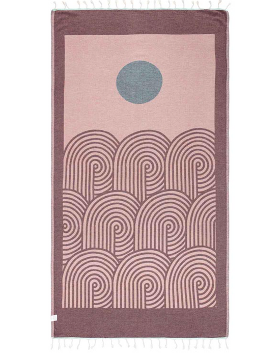 reverse color unfolded view of a sand cloud beach towel with an artful sun and sea inspired design and tassels at the ends