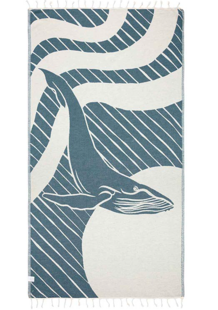 
                      
                        Unfolded view of the reverse side of a beach towel with a whale design and tassels at the ends
                      
                    