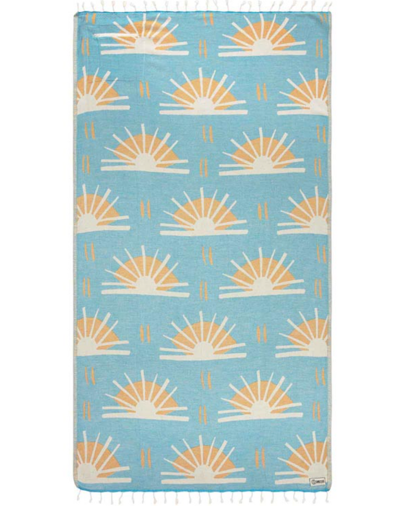 Unfolded view of beach towel with repeated sunburst designs and tassels at the end