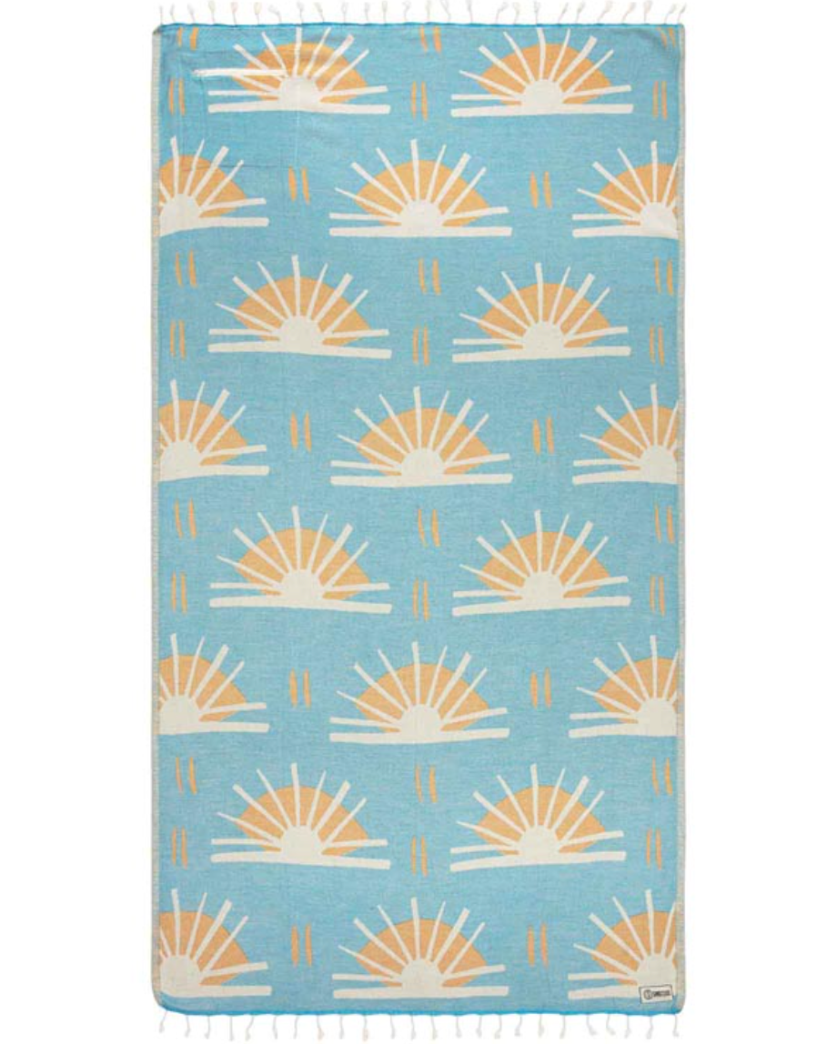 Unfolded view of beach towel with repeated sunburst designs and tassels at the end