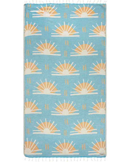 Unfolded view of beach towel with repeated sunburst designs and tassels at the end