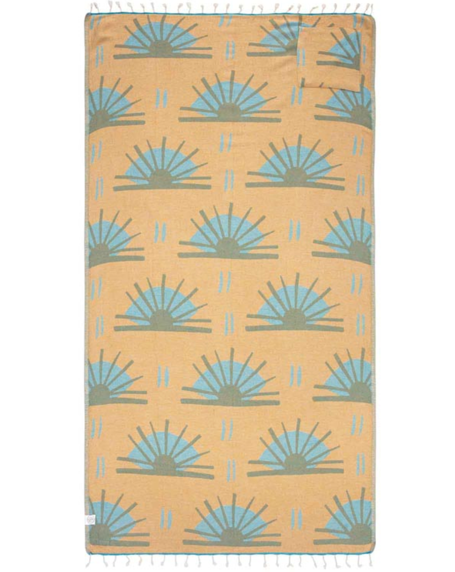 Unfolded view of reverse side of beach towel with repeated sunburst designs and tassels at the end