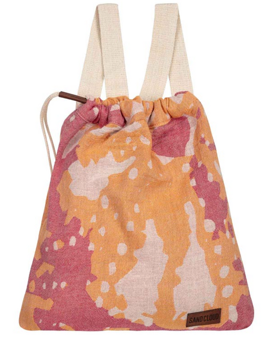 towel with tassels and an artful nature-inspired design folded into it's self-packing bag shape with straps to carry like a backpack
