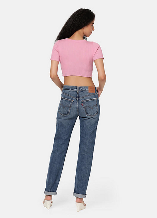 Back view of a woman wearing the medium wash straight leg women's jeans by Levi's