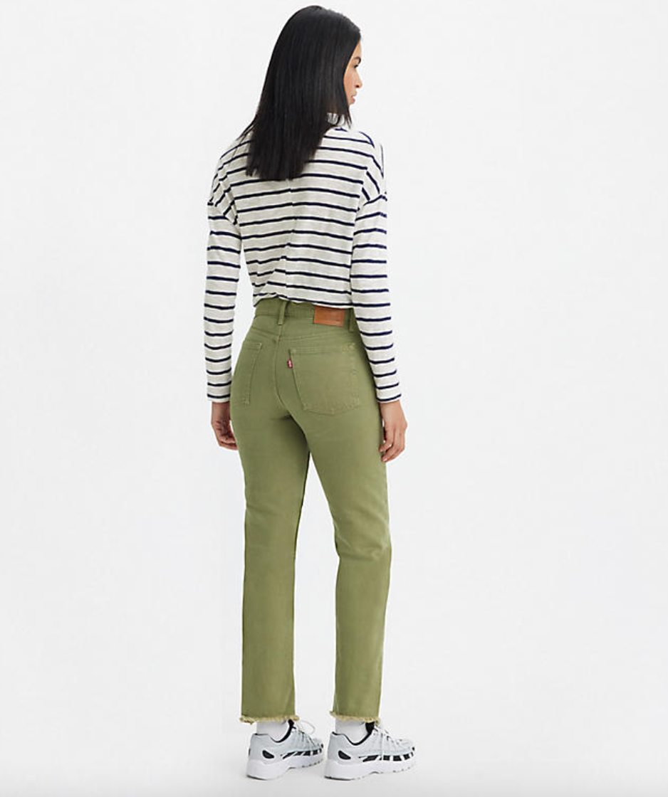 Back view of a woman wearing green high rise straight leg jeans by Levi's