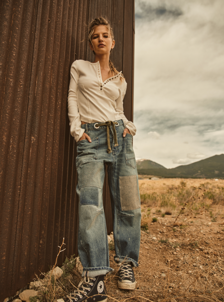 Woman outside wearing Free People's Moxie Low Slung Pull-On Barrel Jeans in the color Truest Blue