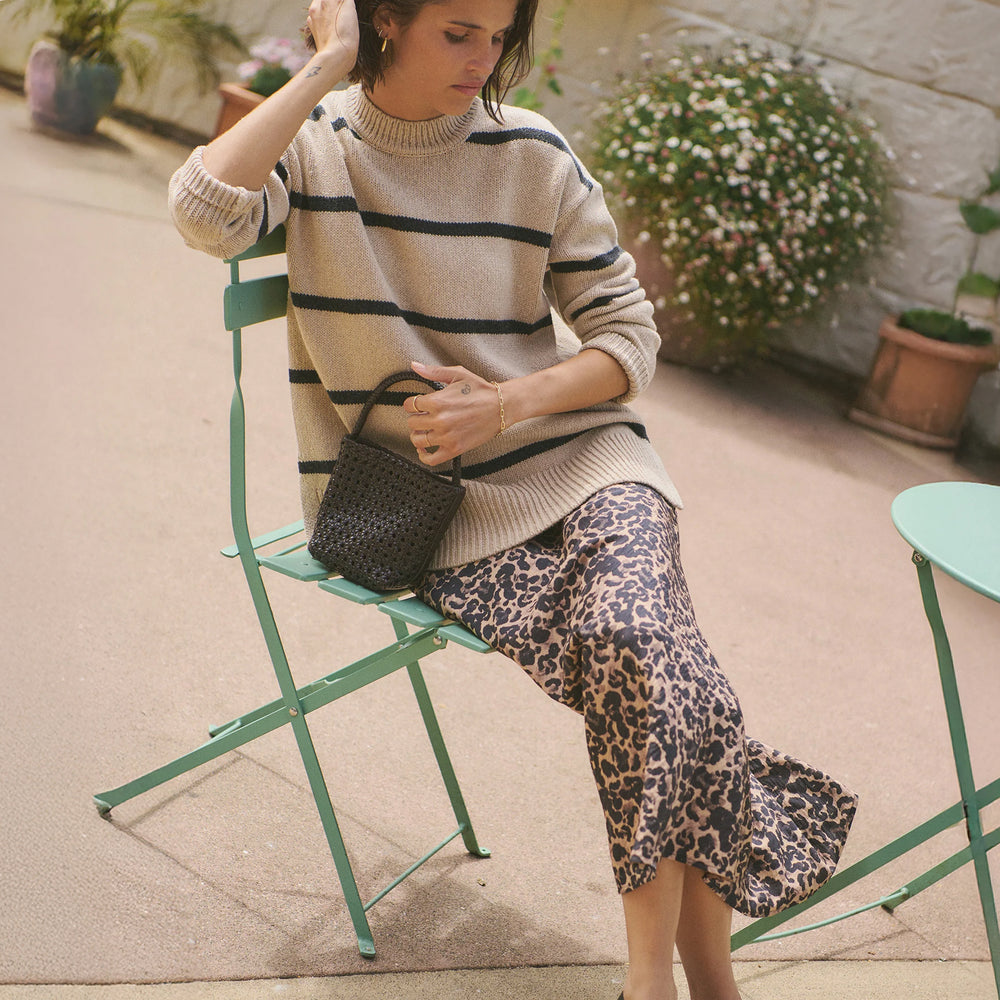 A woman wearing the Avery Midi Skirt in Leopard from Marine Layer. 