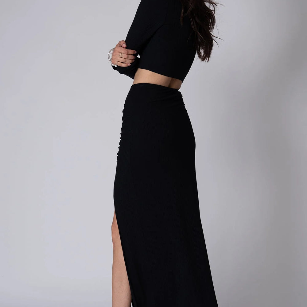 Back view of Stillwater's Get Together Maxi Skirt in the color Black