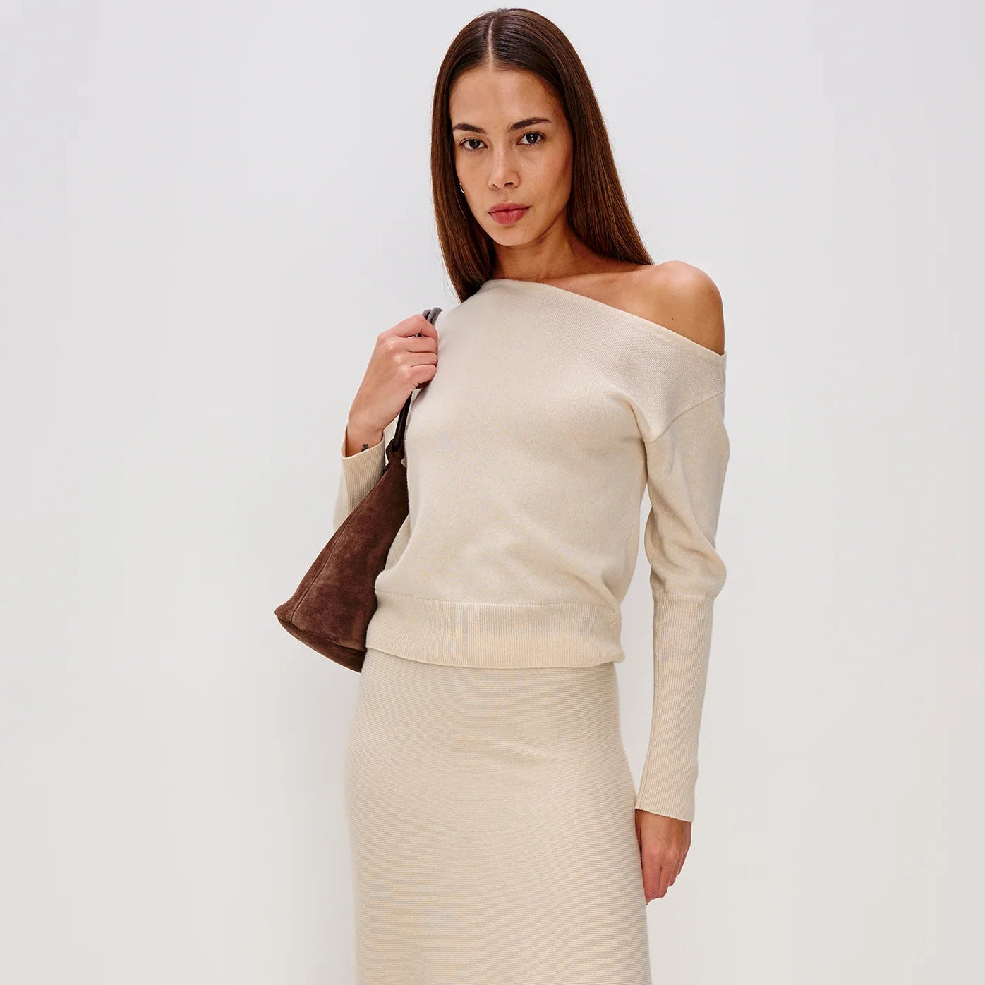 Woman wearing a beige off-shoulder top and skirt from Rails
