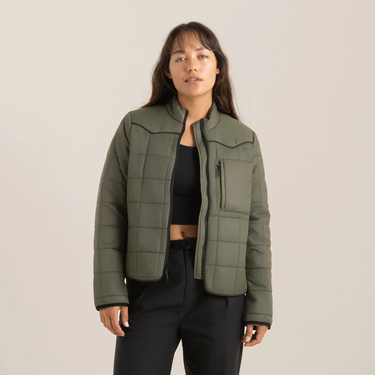 
                      
                        A woman wearing the Base Camp Packable Jacket in the color Military by the brand Roark
                      
                    