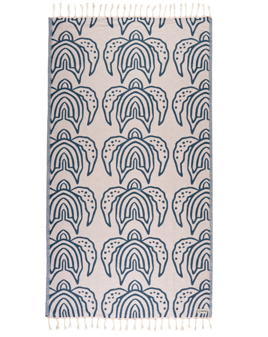 Enjoy your time in the sand with the eco-conscious Sand Cloud Turtle Island Towel, available at Harbour Thread boutique. 
