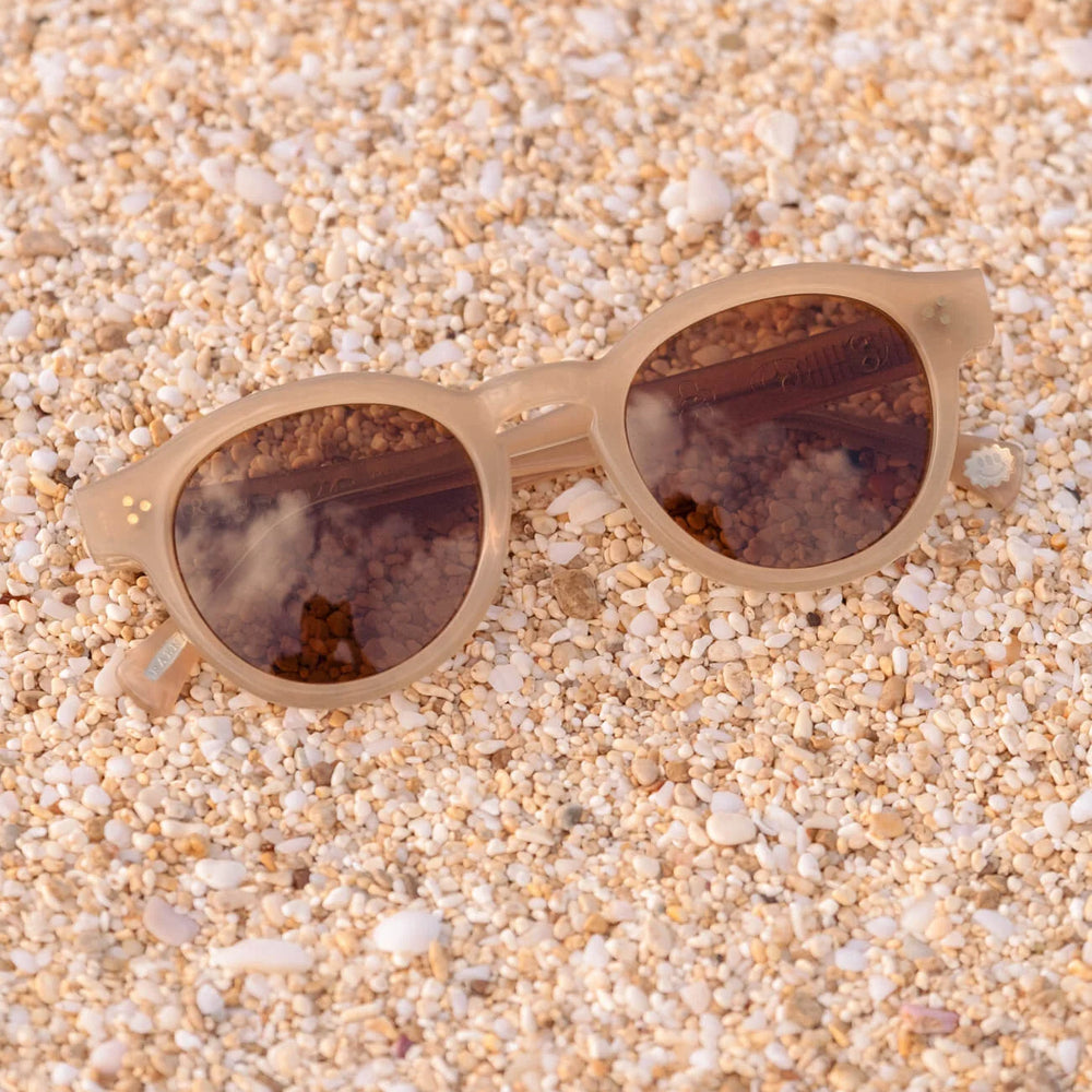 A pair of RAEN's Zelti Unisex Round Sunglasses with Villa frames and Vibrant Brown lenses