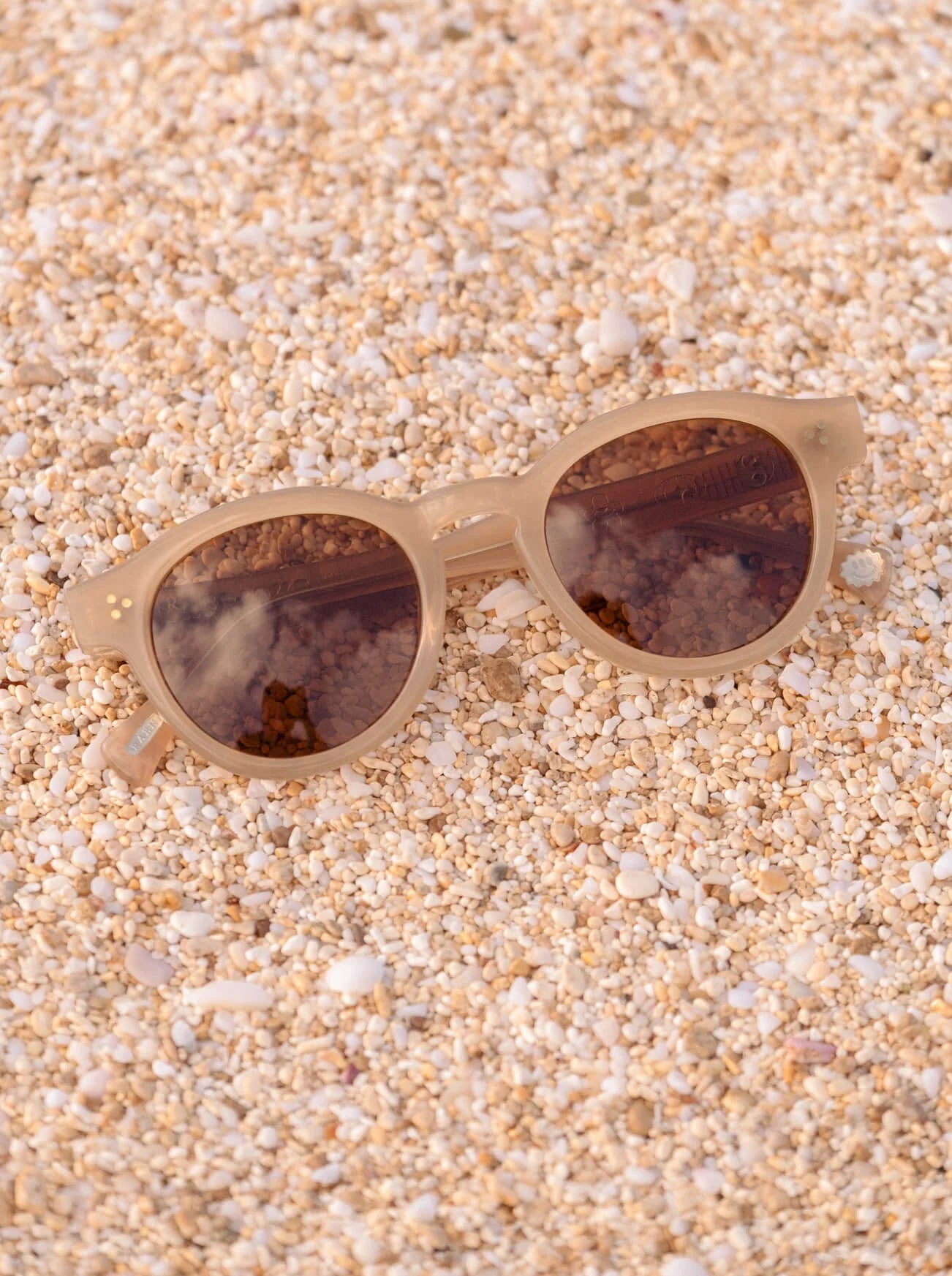 A pair of RAEN's Zelti Unisex Round Sunglasses with Villa frames and Vibrant Brown lenses